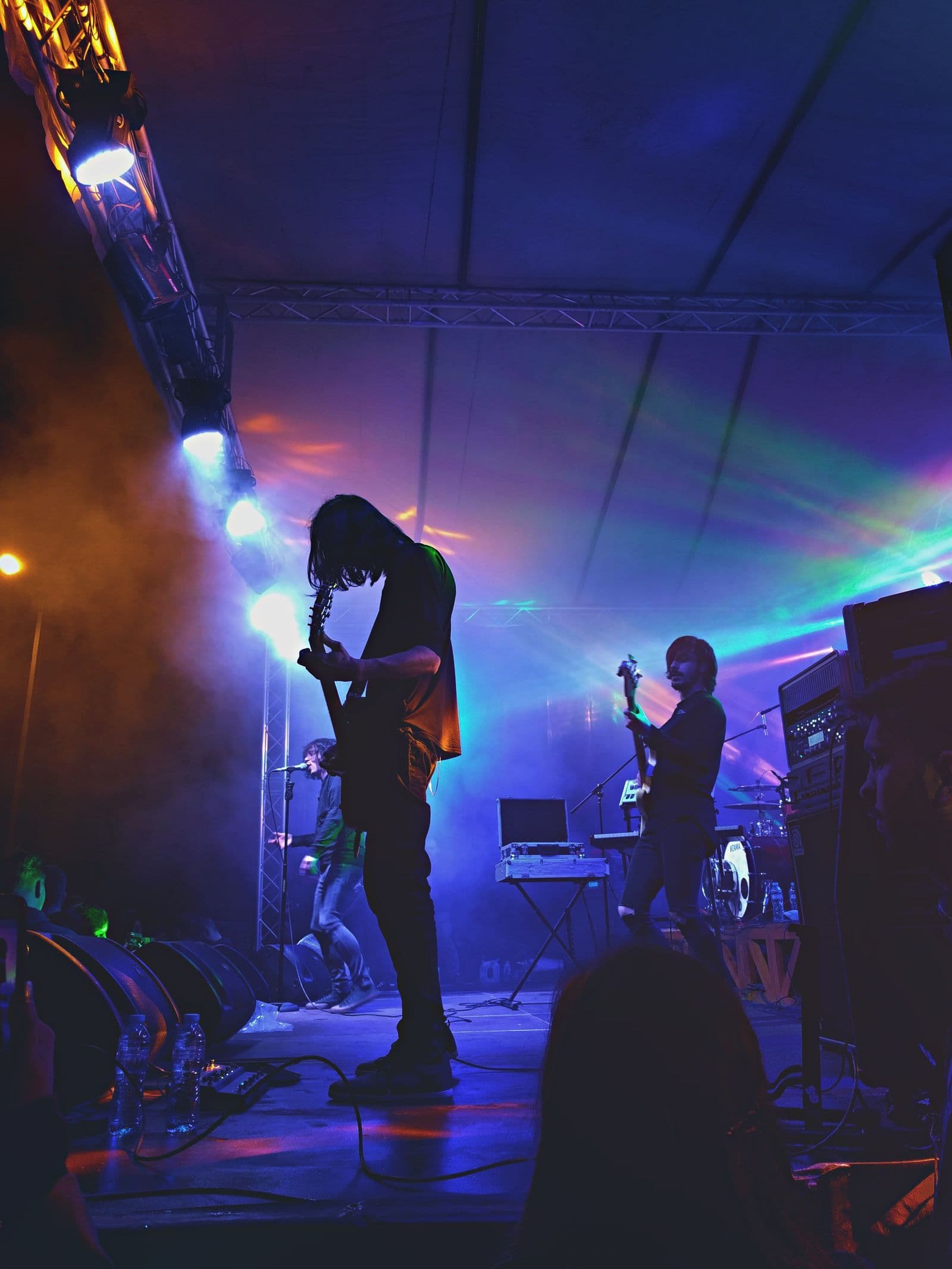 A band playing on stage under coloured lights